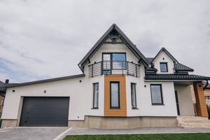 Einfamilienhaus von vorn, weiße Fassadenfarbe.