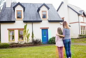 mutter und tochter im rasen stehend vor einem haus